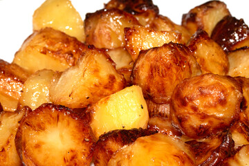 Close up of roast potatoes fresh from being cooked in the oven ready for dinner on white background