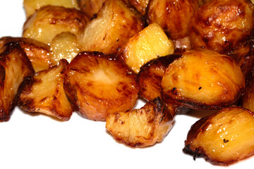 Close up of roast potatoes fresh from being cooked in the oven ready for dinner on white background