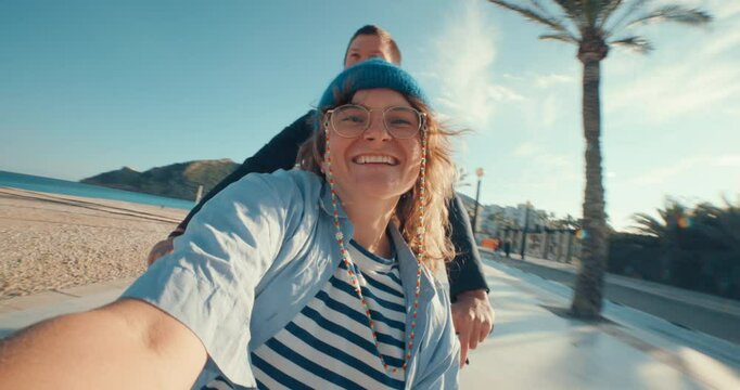 Wide angle POV shot of smartphone of photo camera screen of young woman make selfie when boyfriend drives her around on cargo bicycle in basket. Happy date, energetic and optimistic authentic people