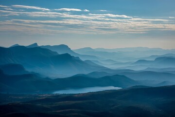 Obraz premium Majestic Mountain Ranges and Serene Lake: A Breathtaking Landscape Panorama at Dawn