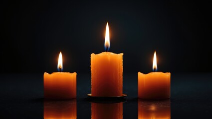 An orange candle flickers in darkness on a black background, symbolizing emotion and reflection