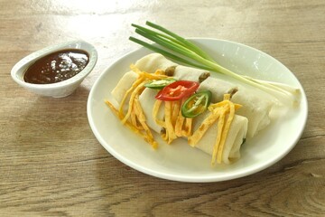 fresh Chinese spring roll made from flour wrapped tofu and pork with bean sprout dressing sweet red gravy sauce on plate   