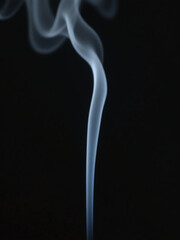 Obraz premium A Thin Stream Of White Incense Smoke Rises Upwards In A Very Slow And Steady Motion.