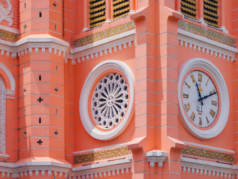 Ho Chi Minh, Vietnam - Sept 30, 2023: Clock and rose window detail on facade of iconic pink Tan Dinh Church.