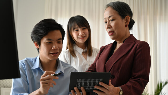 Creative divers team reviewing a colour palette. Young designer presents ideas to a senior advisor and colleague