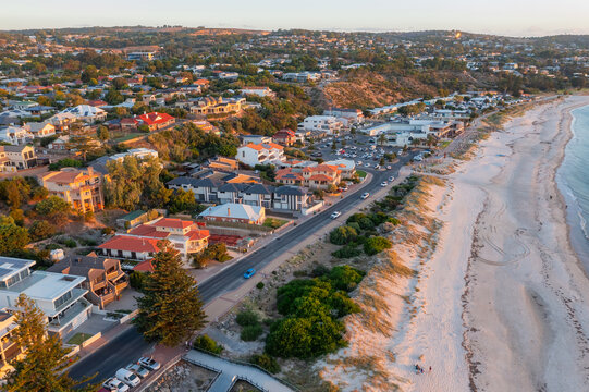Fototapeta Aerial view of buildings along a coastal esplande and surrounding city real estate