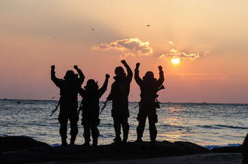 Silhouettes of Korean army soldiers looking at the sunrise