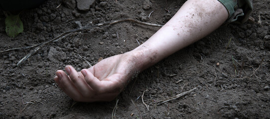 Hand of a wounded soldier on the ground