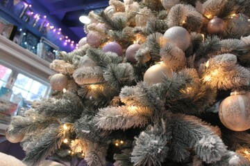 Beautifully decorated Christmas tree with frosted branches and sparkling lights in festive indoor setting