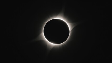 Spectacular total solar eclipse revealing solar prominences at the black moon's edge with radiant corona during totality.