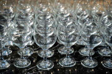 Many empty clean wine glasses on dark background in daylight