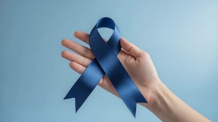 Navy blue awareness ribbon with a bow on a hand