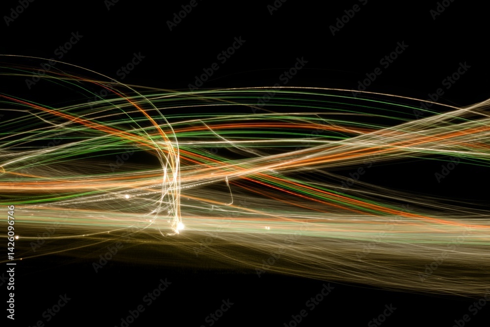 Poster Colorful light trails create abstract patterns in the dark during a nighttime long exposure photography session