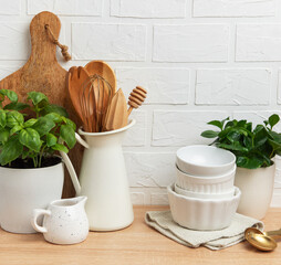 Kitchen utensils and plants creating cozy atmosphere on wooden countertop
