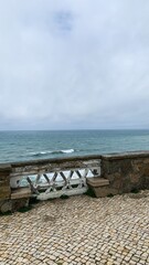 Stone pathway overlooking the serene ocean, ideal travel escape, beach holiday, tranquil seaside...