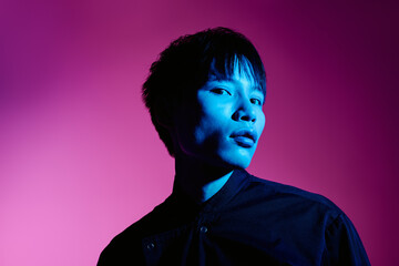 Stylish Asian man exudes charisma in bold colors with a striking lighting setup.