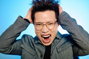 Joyful young man exuberantly showcases his stylish look against a bright blue background.