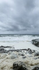Stormy ocean waves crashing against rocky shore, scenic marine landscape, coastal weather,...