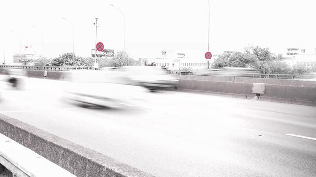 Vue tr&egrave;s acc&eacute;l&eacute;r&eacute;e de voitures sur le p&eacute;riph&eacute;rique parisien, avec effet noir blanc et rouge