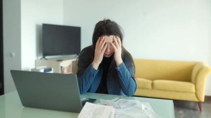Stressed woman overwhelmed by financial issues and paperwork at home desk