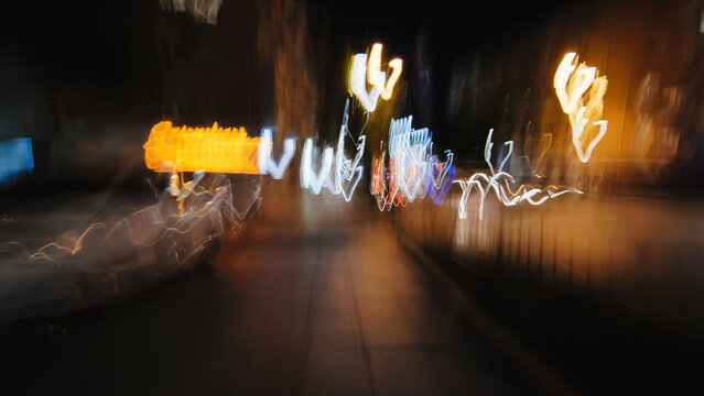 Light trails dancing across urban nightscape, blending motion and city glow through evening pedestrian perspective