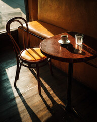A wooden table with a cup and a glass of water on it