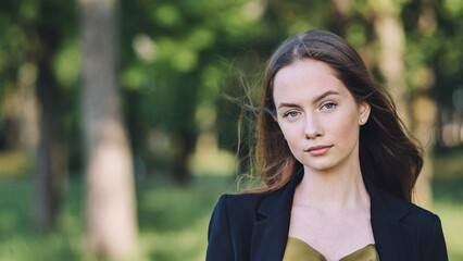 Portrait of a businesswoman posing in a park, conveying confidence, professionalism, and success in...