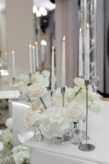 Wedding decor, flowers, candles in candlesticks on the table at a banquet in a restaurant.