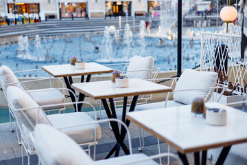 Elegant outdoor seating near a fountain in a vibrant urban plaza during evening hours