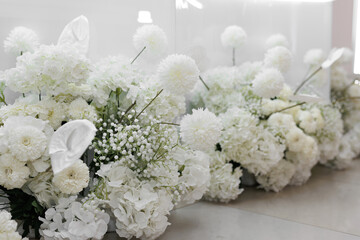 Close-up of the decor of white flowers at the wedding. Lush artificial flowers in the restaurant.