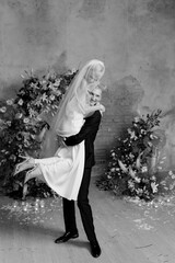 Beautiful happy wedding couple laughing and smiling near the arch, black and white photo