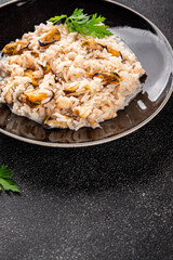 Seafood rice risotto frut de mer mussels, shrimp, prawn, rapan, squid vegetable dish fresh delicious gourmet food background on the table rustic food top view copy space