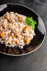 Seafood rice risotto frut de mer mussels, shrimp, prawn, rapan, squid vegetable dish fresh delicious gourmet food background on the table rustic food top view copy space