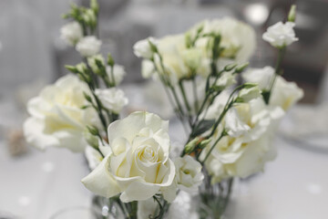 Wedding table decor. Appliances, fresh flowers, candles in glass vases in close-up.