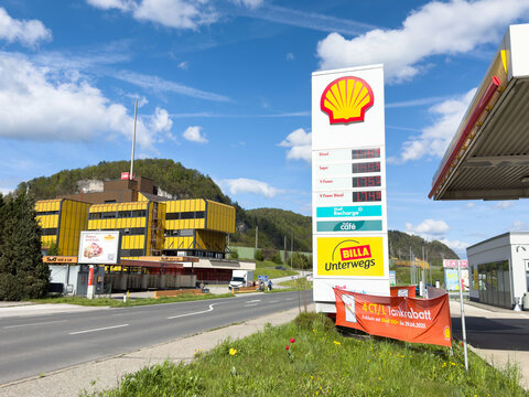 Sunny day at shell gas station with price board and near roadside in scenic countryside setting