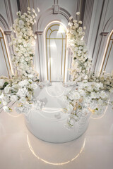 Luxurious wedding decor in the restaurant. Flowers, a spotlight, pearl beads.