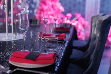Elegant table setting with a bright pink napkin on a white plate.