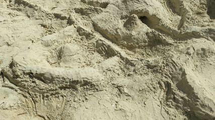 Detailed view of a homemade sandcastle featuring intricate paths, towers and natural textures sculpted in fine beach sand