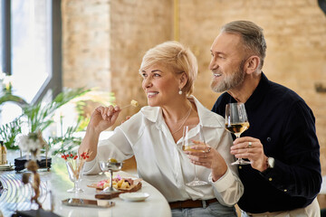 Romantic evening for a mature couple enjoying wine and appetizers at a cozy restaurant
