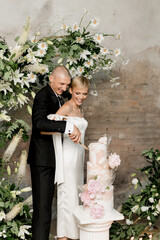 Young couple in love cutting their beautiful wedding cake