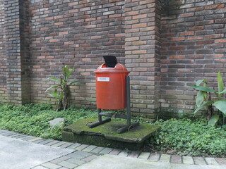 red brick wall with trash can