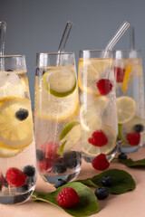refreshing glasses of sparkling water infused with lemon, lime, and berries, featuring condensation and vibrant colors, evoking a fresh and invigorating summer atmosphere. natural, texture, balance
