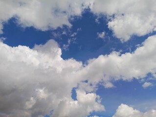 White Clouds Adorn a Bright Blue Sky, Shaping an Ethereal Landscape