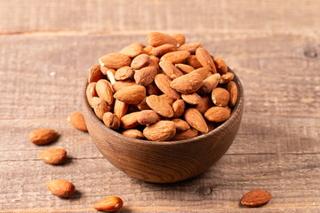 Raw peeled almonds in brown bowl