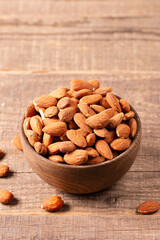 Raw peeled almonds in brown bowl
