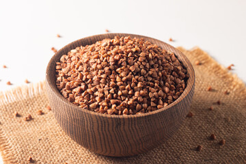 Buckwheat groats on wooden background. Healthy cereal concept.  