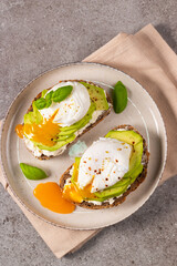 Toast with avocado, soft cream cheese, rye bread and poached Egg. Wholemeal open sandwich for healthy breakfast concept