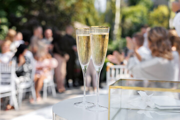 Close-up of wine glasses filled with champagne and wedding rings.