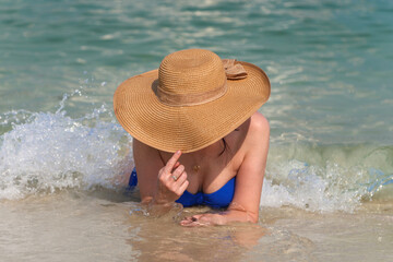moment of summer happiness, a woman basks in the gentle waves of the sea.