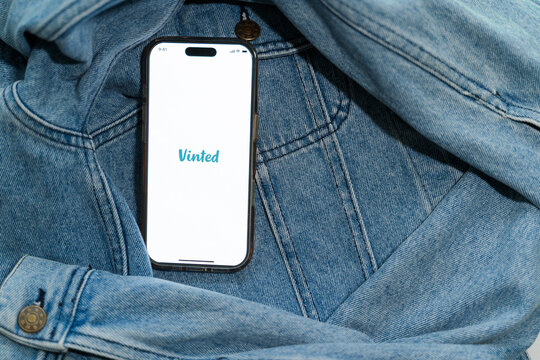 Closeup of a smartphone with Vinted logo.